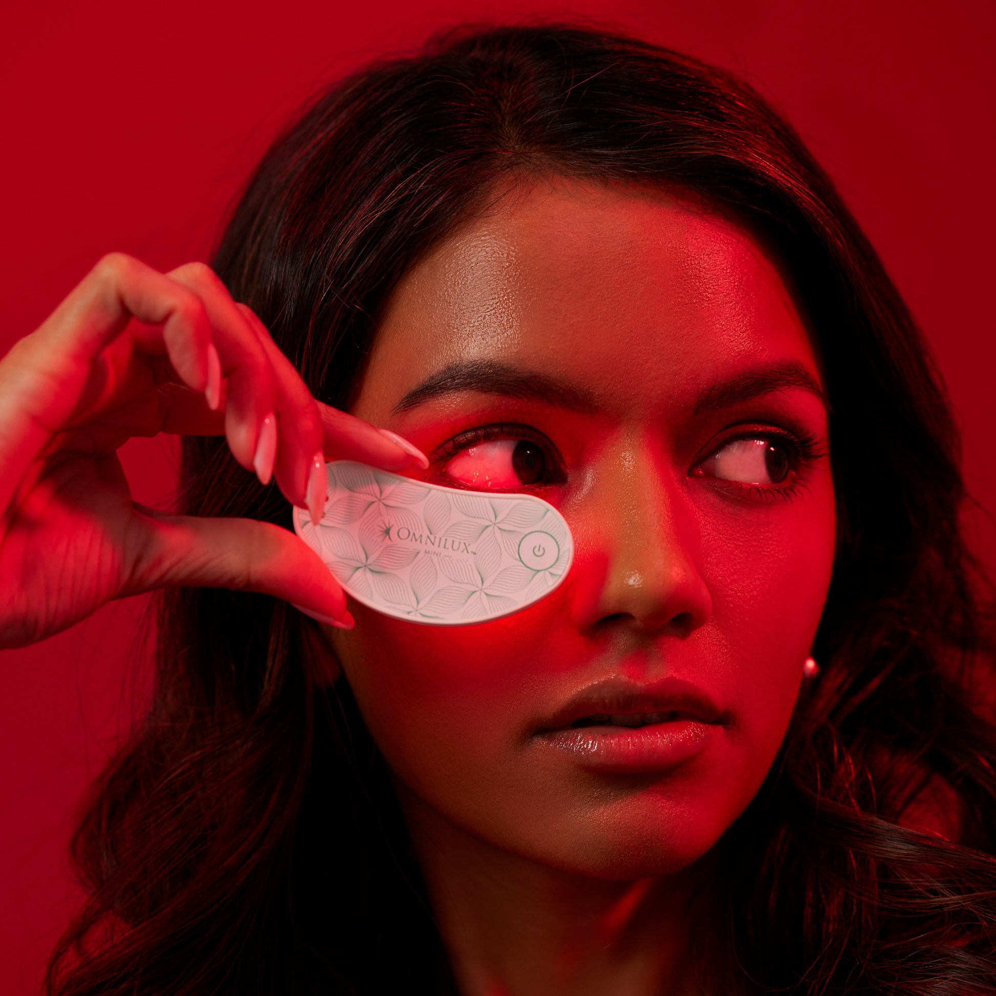 woman using omnilux eye brightener infrared led device