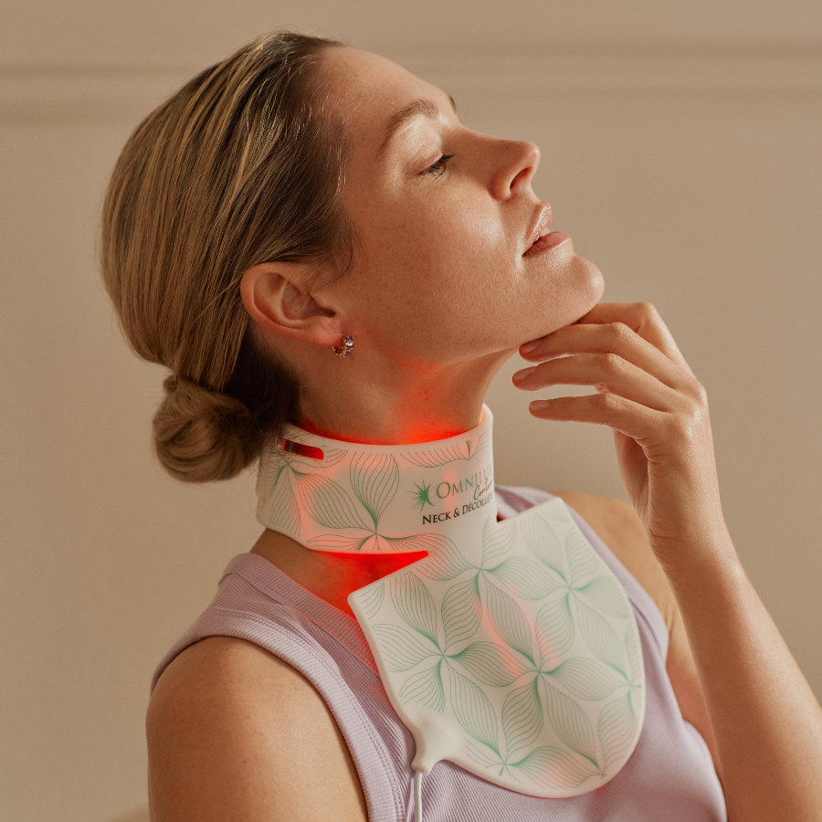 Lifestyle image of woman wearing omnilux neck and decolletage skin light therapy