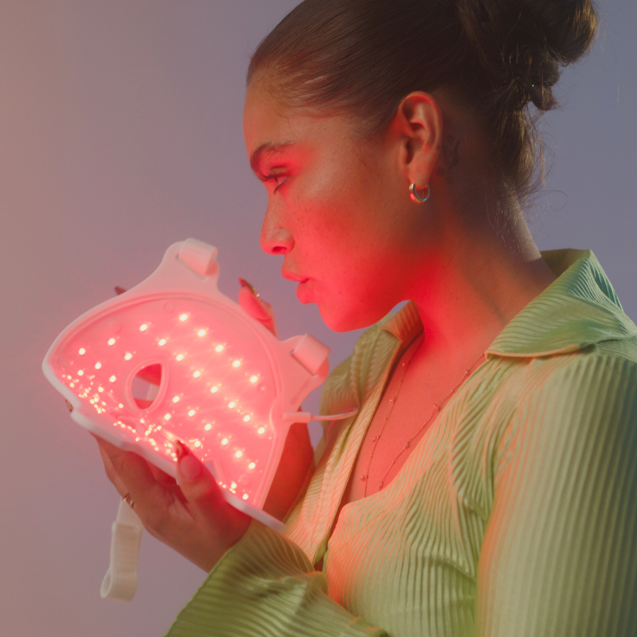 Woman about to put on omnilux contour light therapy mask