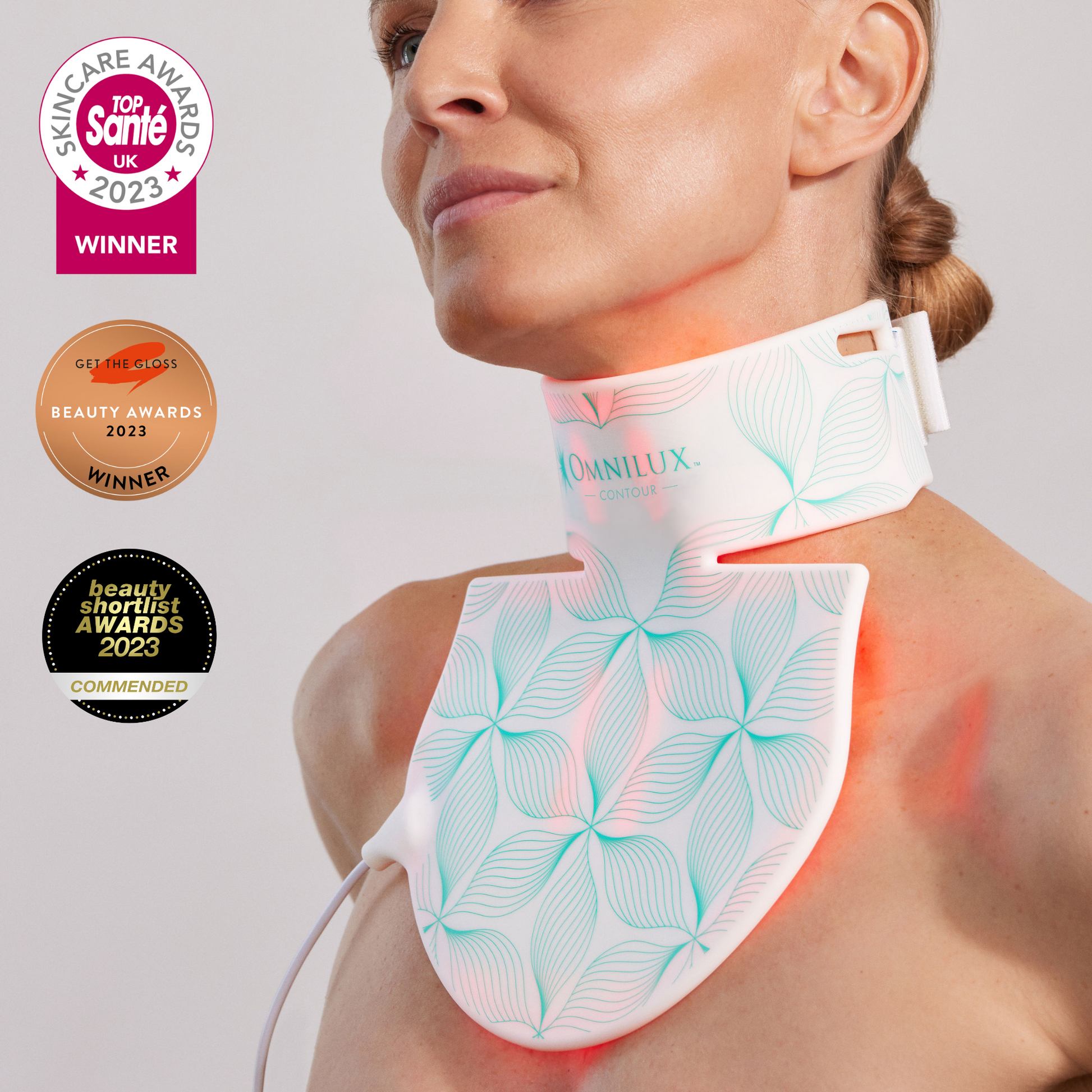 Woman wearing omnilux neck and decolletage infrared light skin therapy