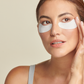 Lifestyle image of woman wearing total eye hydrogel treatment masks under her eyes